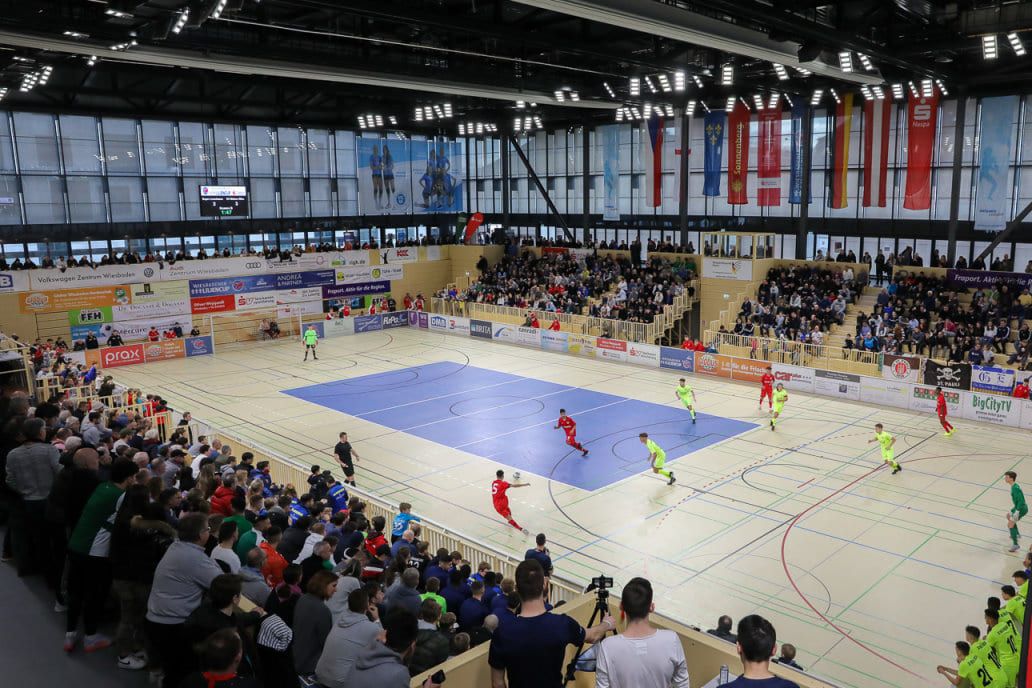 Blick von der Tribüne über das Spielfeld auf die gefüllten Ränge der Sporthalle.