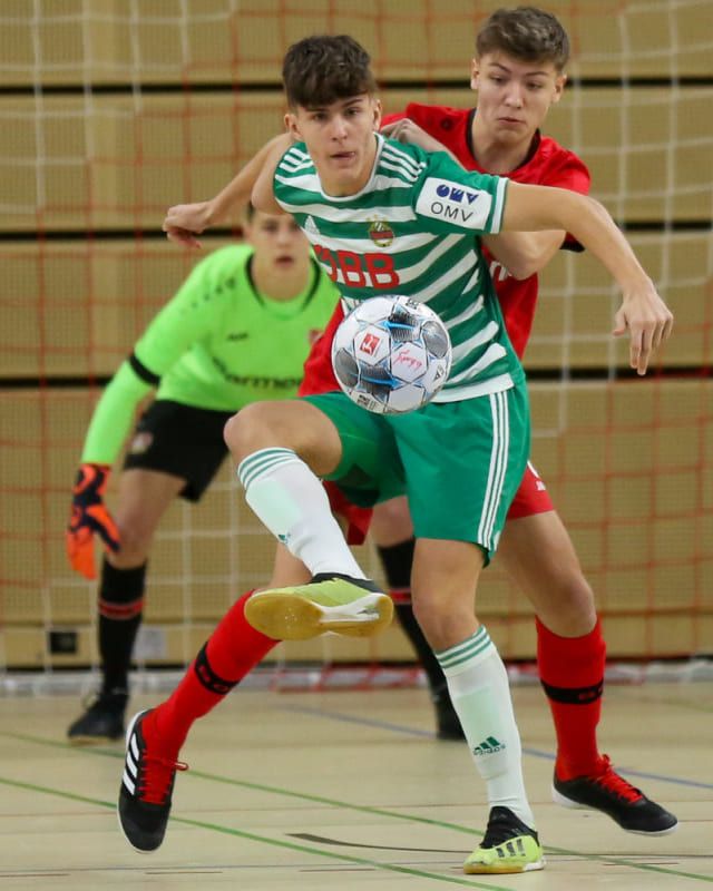 Zwei U17-Spieler kämpfen um den Ball, dahinter unscharf der Torwart.
